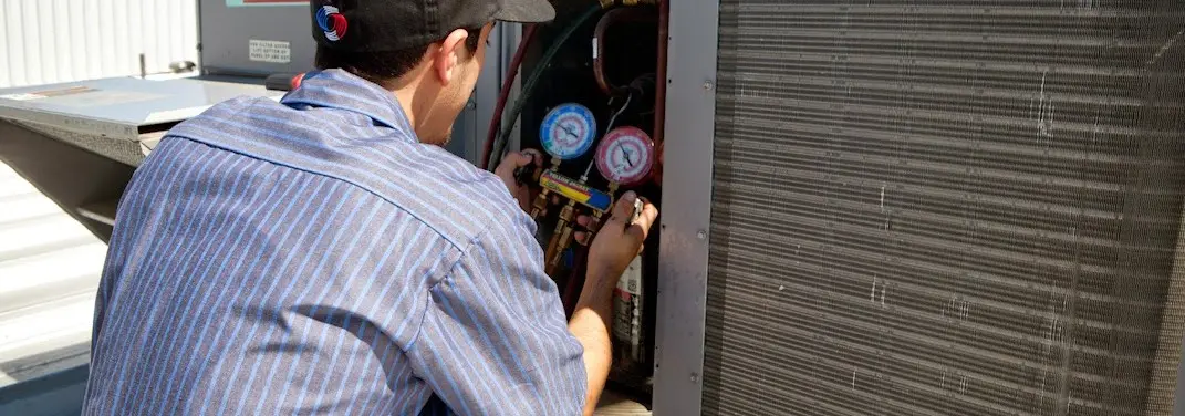 HVAC technician servicing a condenser unit in Union Park